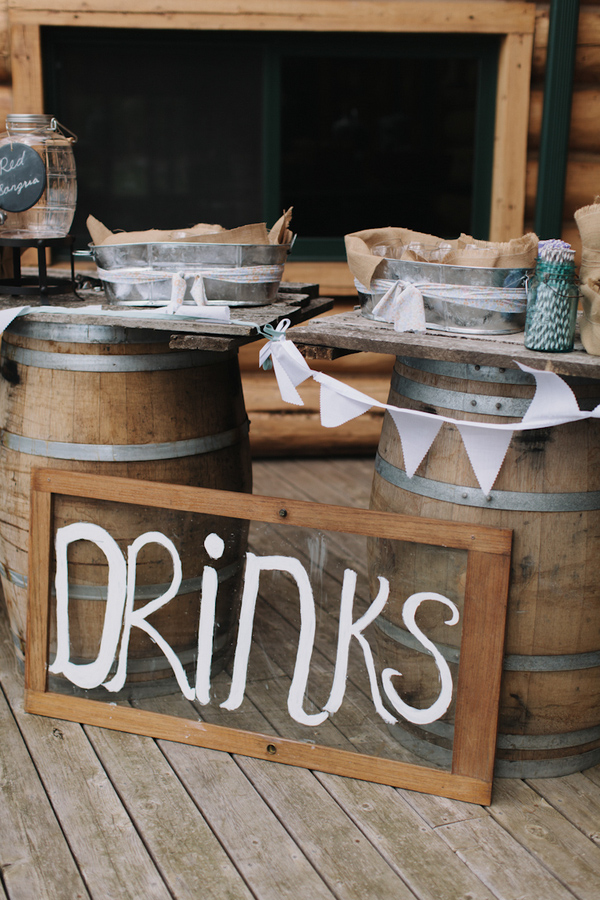 Reception decor with rustic barrels as drink table - wedding photo by Michigan-based wedding photographers Bryan and Mae